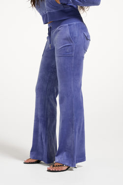 Displays a model wearing the Grey&blue 'Juicy' branded Low Rise Flare Classic Velour Track Pant