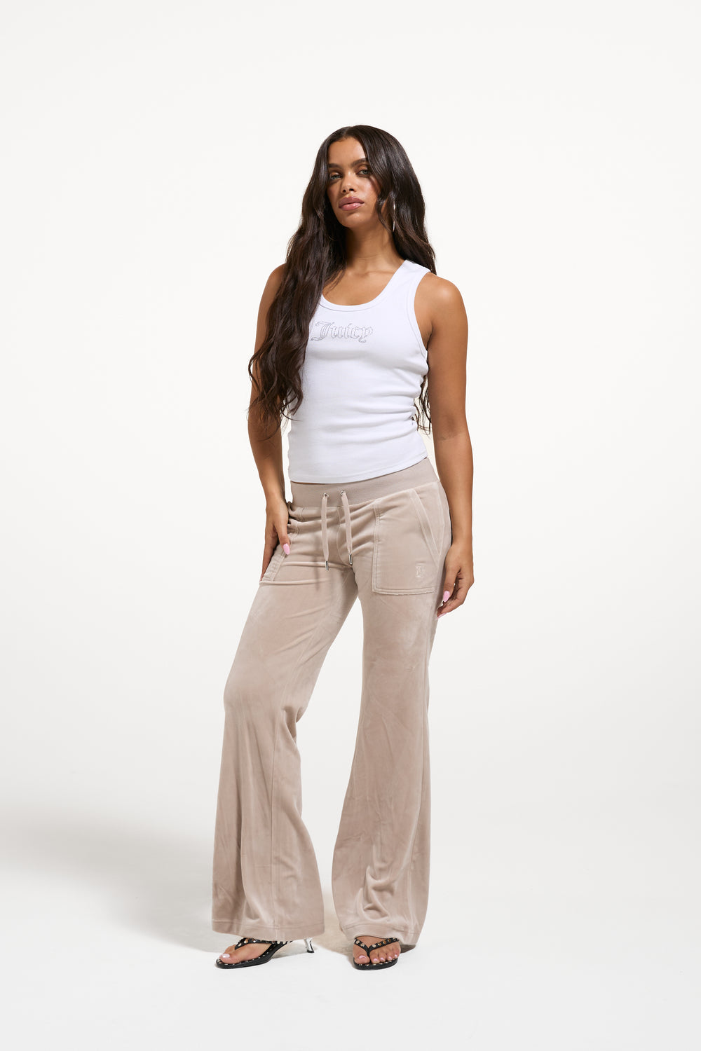 Displays a model wearing the String 'Juicy' branded low rise flare pocket classic velour track pant 