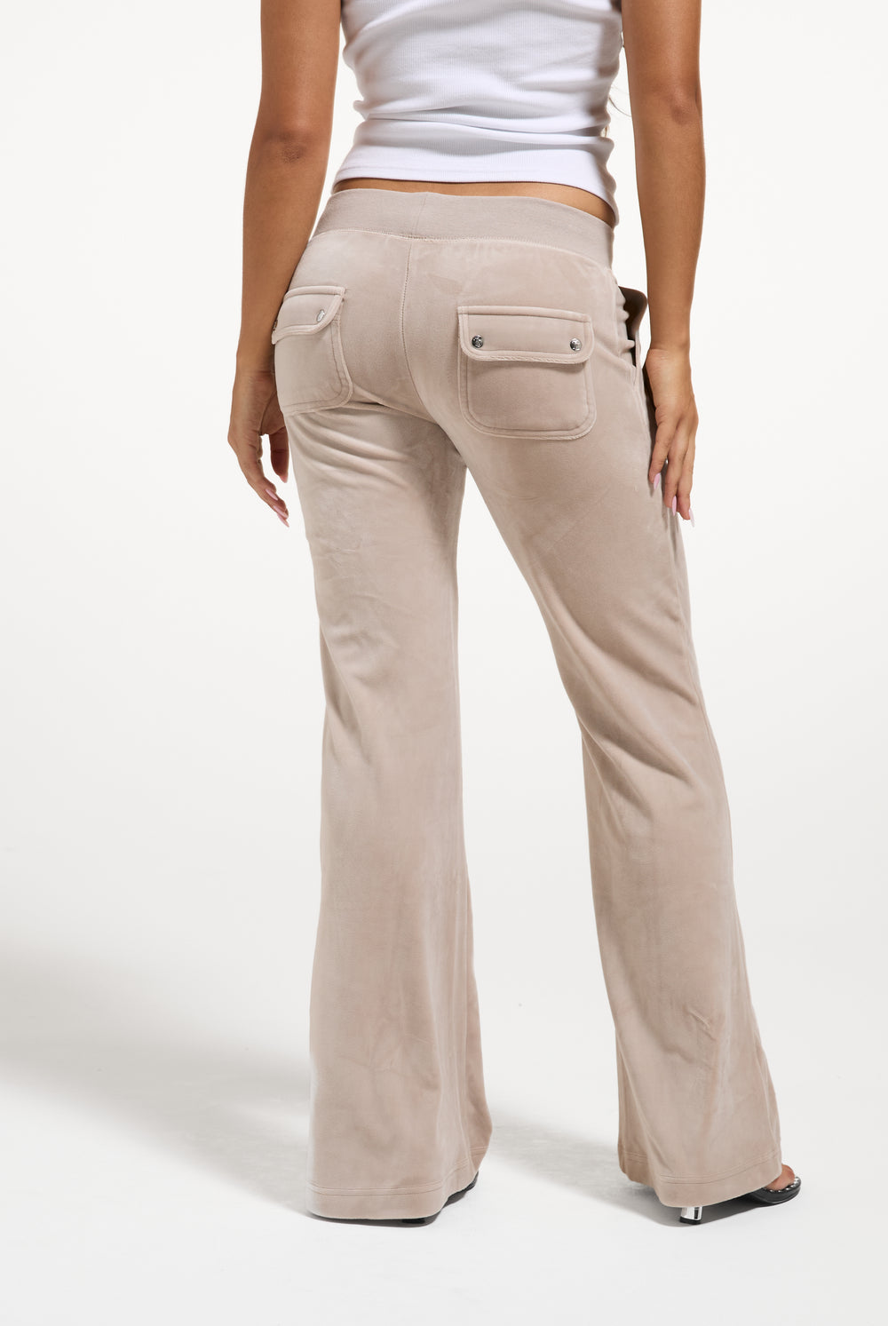 Displays a model wearing the String 'Juicy' branded low rise flare pocket classic velour track pant 