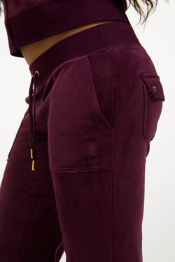 Displays a model wearing the Winetasting & Gold 'Juicy' branded Low Rise Flare Classic Velour Track Pant
