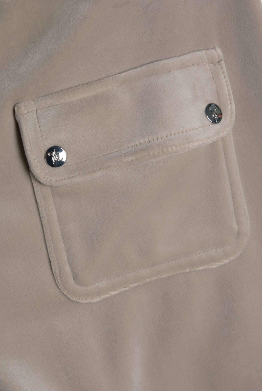 Displays the String 'Juicy' branded low rise flare pocket classic velour track pant featuring the details on the pockets