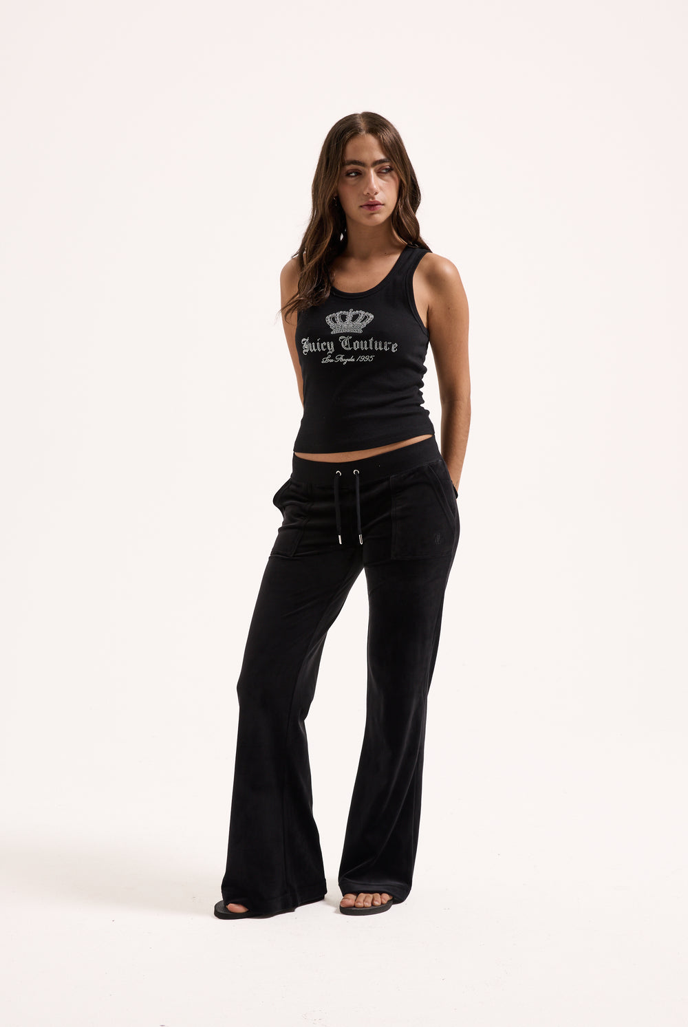 Displays a model wearing the Black Low rise flare pocket 'Juicy' branded classic velour track pant