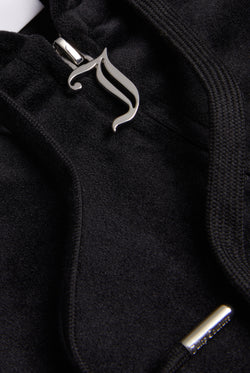 Close-up of the silver Juicy Couture zip detailing on a black velour hoodie
