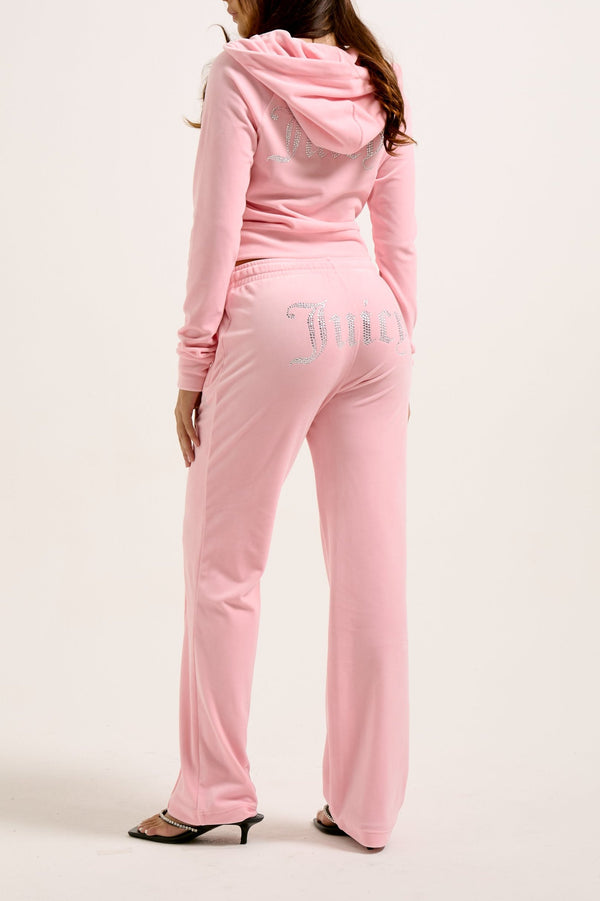 Displays a model wearing the Juicy Pink 'Juicy' branded velour diamanté tracksuit bottoms 