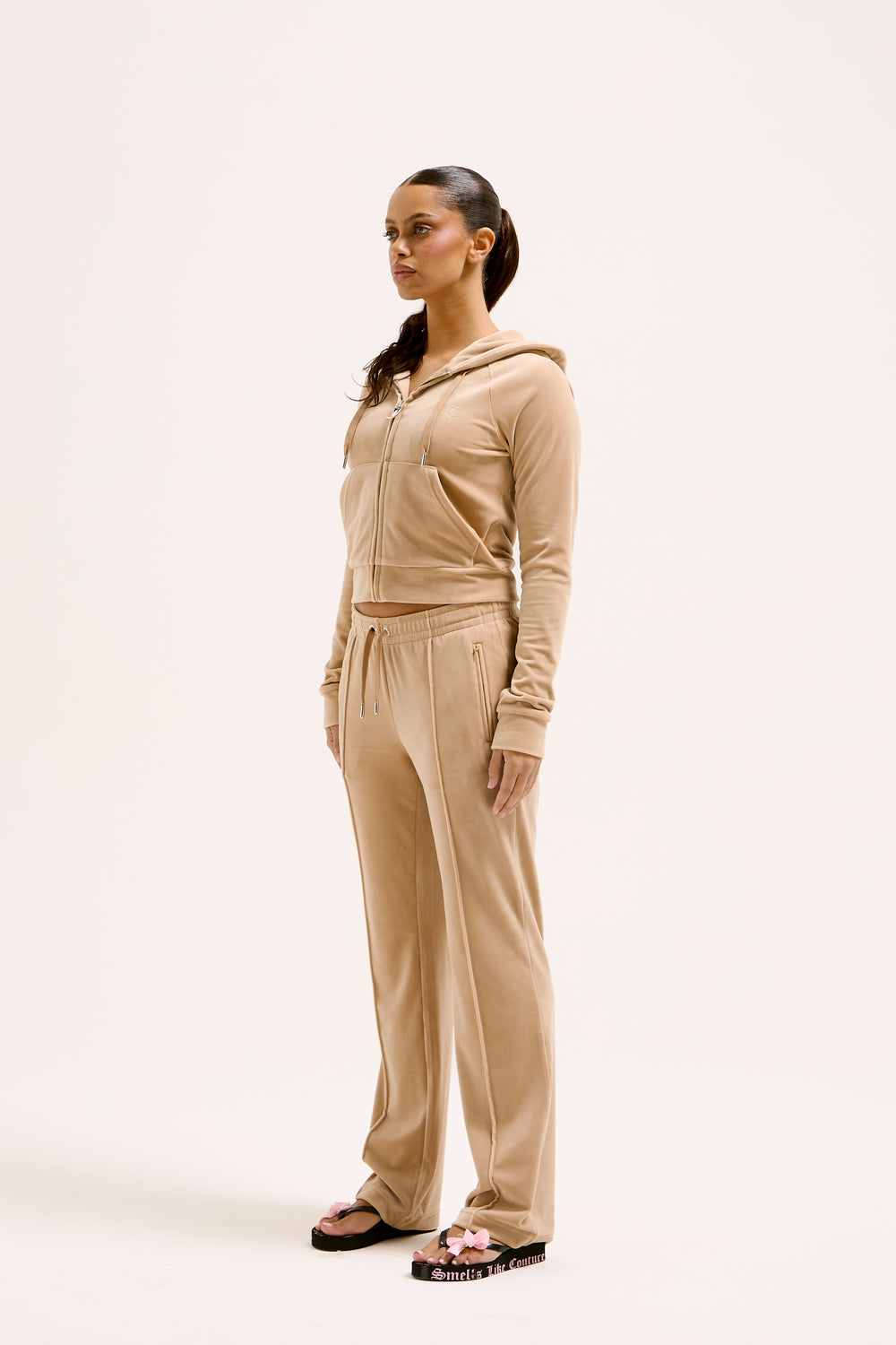 Displays a model wearing the Nomad 'Juicy' branded Velour Diamanté tracksuit bottom 