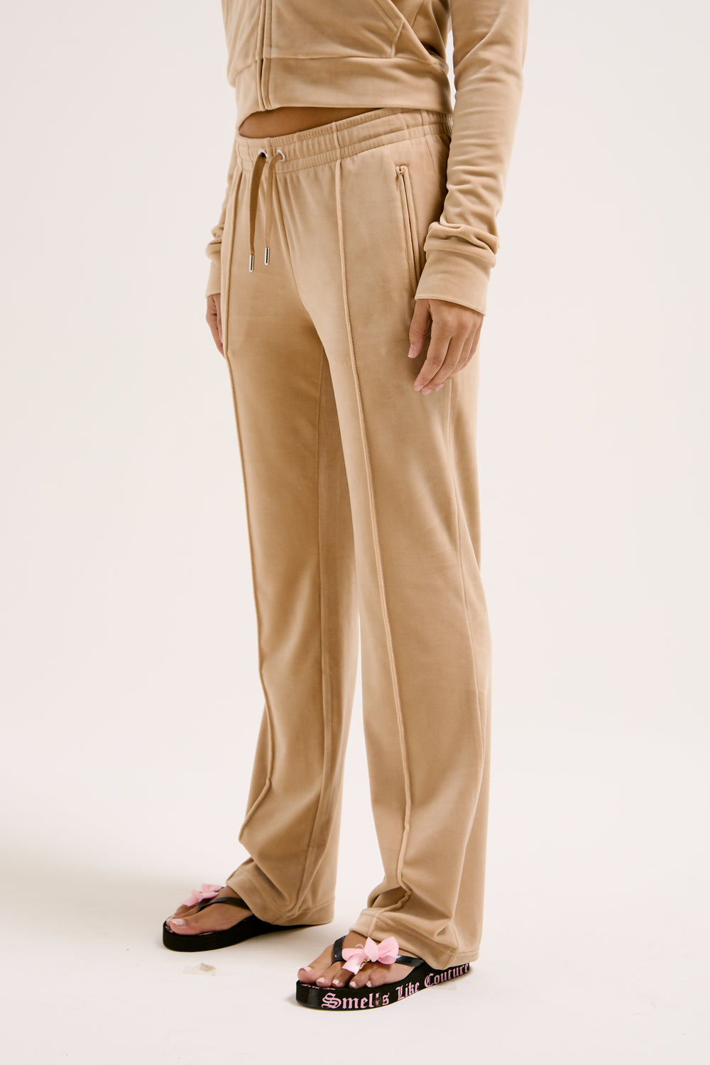 Displays a model wearing the Nomad 'Juicy' branded Velour Diamanté tracksuit bottom 