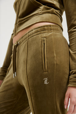 Displays a model wearing the Dark Olive 'Juicy' branded velour diamanté tracksuit bottom