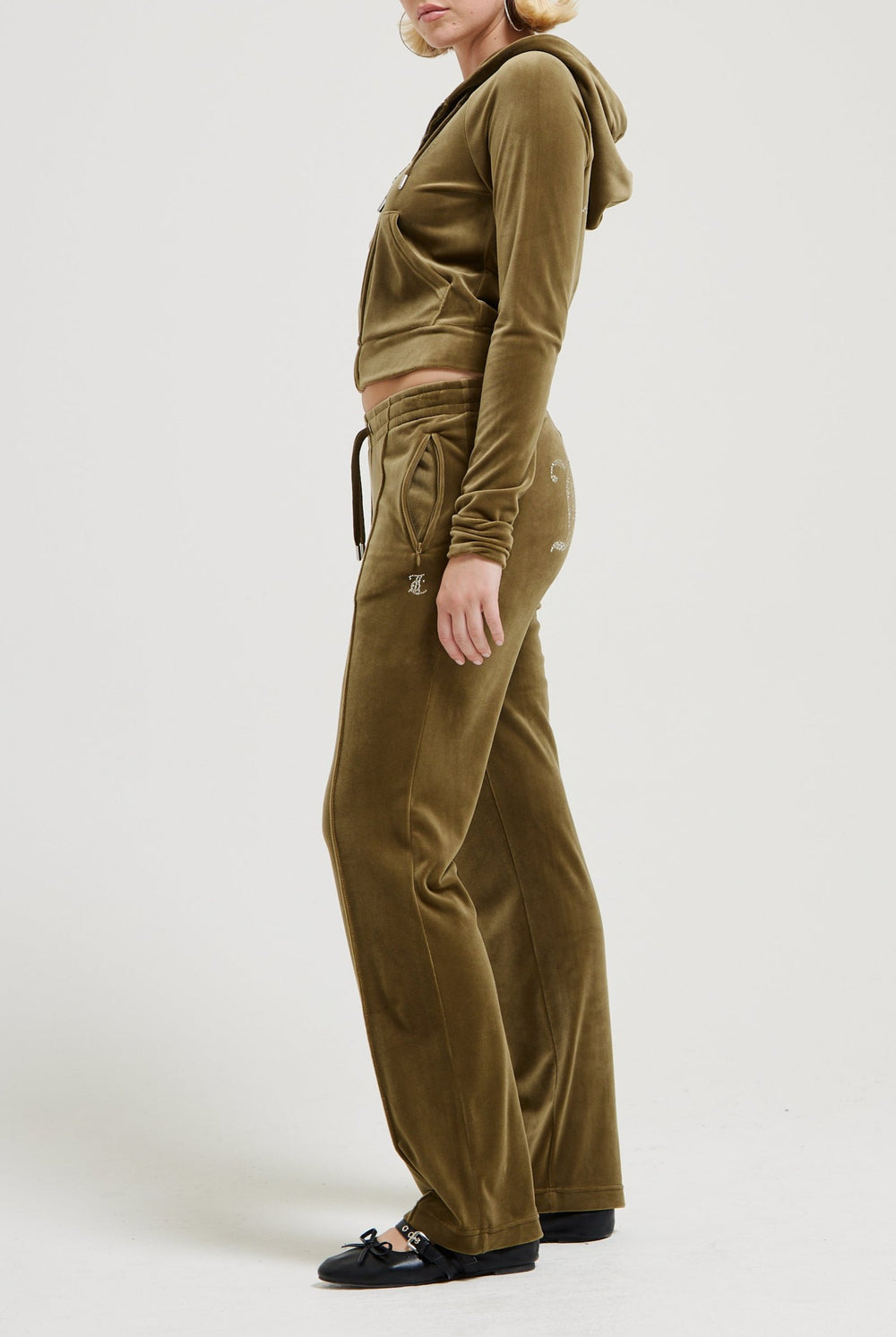 Displays a model wearing the Dark Olive 'Juicy' branded velour diamanté tracksuit bottom