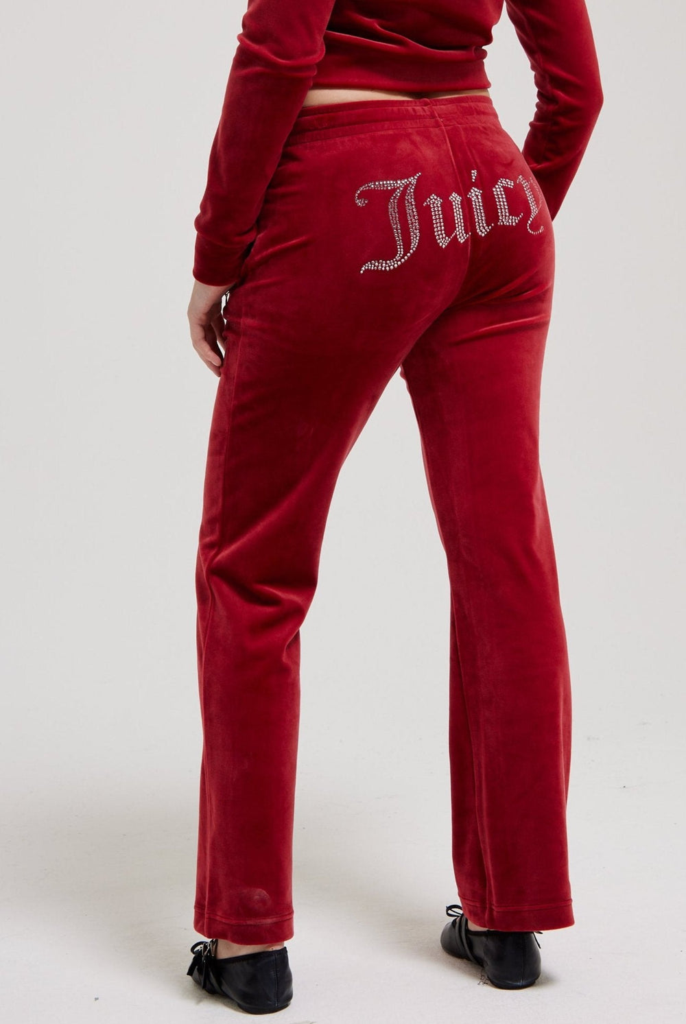 Displays a model wearing the Red Dahlia 'Juicy' branded velour diamanté tracksuit bottom