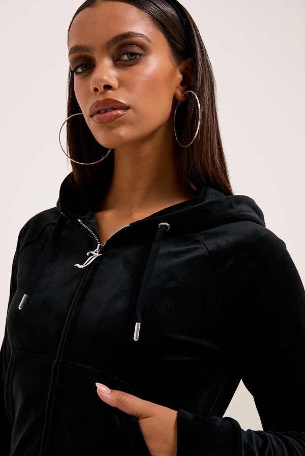 Displays a model wearing the Black 'Juicy' branded outline diamanté velour zip-through hoodie 