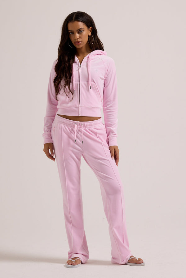 Displays a model wearing the Cherry Blossom 'Juicy' branded velour outline diamanté tracksuit bottom  