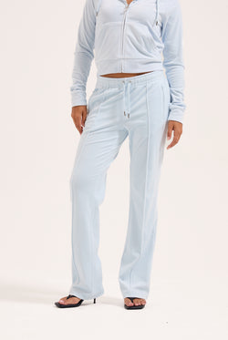 Displays a model wearing the Nantucket Breeze 'Juicy' branded velour outline diamanté tracksuit bottom 