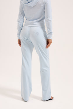 Displays a model wearing the Nantucket Breeze 'Juicy' branded velour outline diamanté tracksuit bottom 