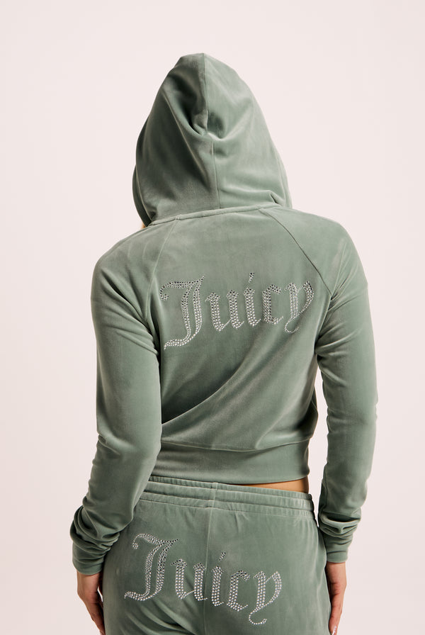 Displays a model wearing the Chinois Green 'Juicy' branded diamanté velour zip-through hoodie 