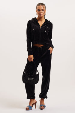 Woman wearing a black tracksuit with a handbag on a white background