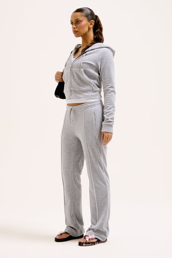 Displays a model wearing the Silver Marl Diamanté 'Juicy' branded cotton velour tracksuit bottom  