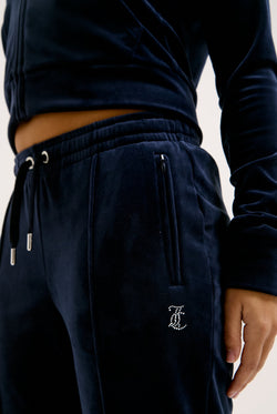 Displays a model wearing the Night Sky 'juicy' branded velour diamanté tracksuit bottom
