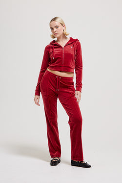 Displays a model wearing the Red Dahlia 'Juicy' branded velour diamanté tracksuit bottom