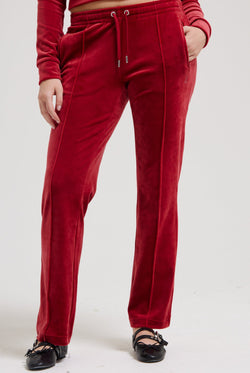 Displays a model wearing the Red Dahlia 'Juicy' branded velour diamanté tracksuit bottom