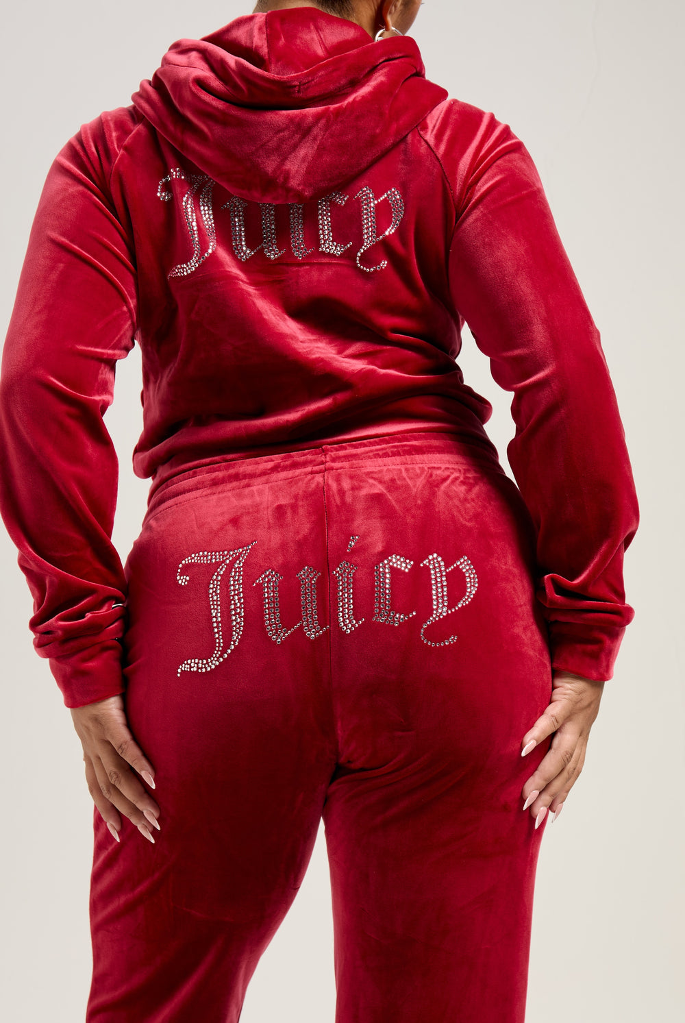Displays a model wearing the Red Dahlia 'Juicy' branded velour diamanté tracksuit bottom