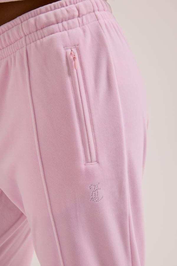 Displays a model wearing the Cherry Blossom 'Juicy' branded velour outline diamanté tracksuit bottom  