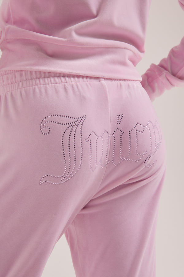 Displays a model wearing the Cherry Blossom 'Juicy' branded velour outline diamanté tracksuit bottom  