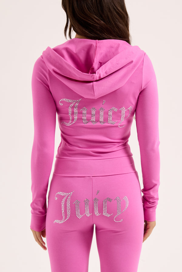 Displays a model wearing the super pink 'juicy' branded diamanté luxury jersey low rise pant 