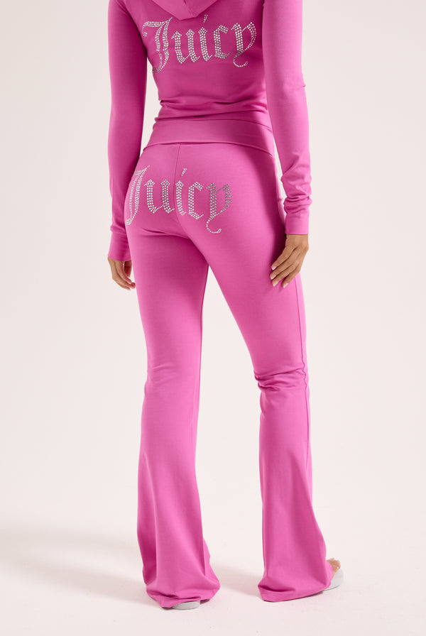 Displays a model wearing the super pink 'juicy' branded diamanté luxury jersey low rise pant 