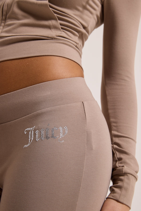 Displays a model wearing the Fungi 'juicy' branded diamanté luxury jersey low rise pant 