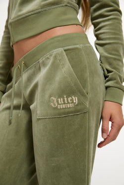 Displays a model wearing the Oil Green 'Juicy' branded Regal Rebelle Caisa Ultra Low Rise Pant