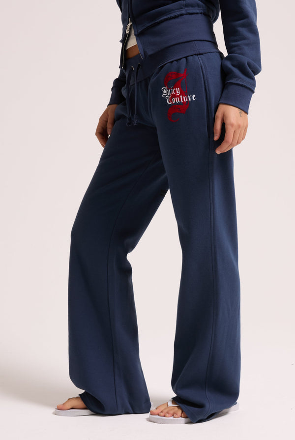 Displays a model wearing the Mood indigo relaxed fit 'juicy' branded flare fleece track pant 