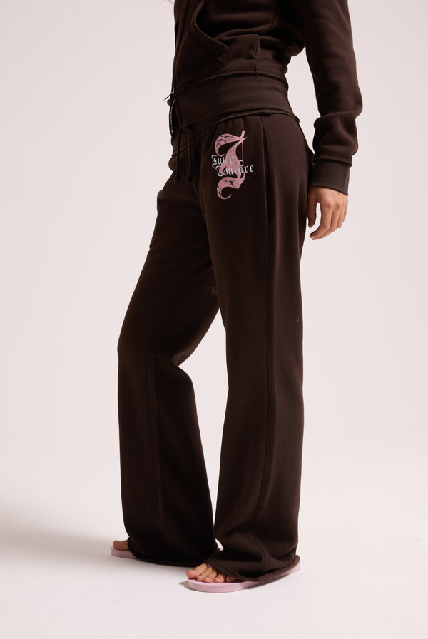 Displays a model wearing the Java 'Juicy' branded relaxed fit flare fleece trackpant