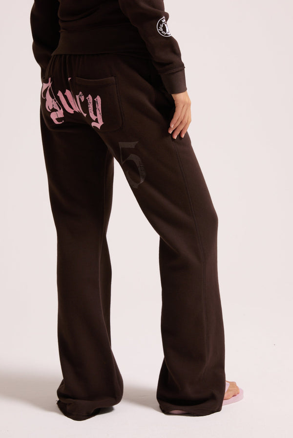 Displays a model wearing the Java 'Juicy' branded relaxed fit flare fleece trackpant