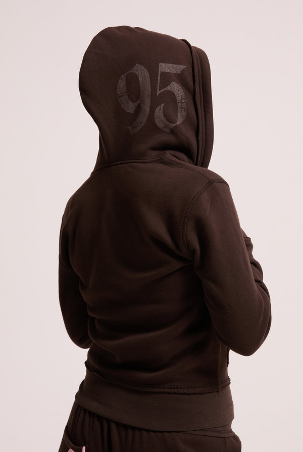 Displays a model wearing the Java longline 'Juicy' branded fleece zip through hoodie 