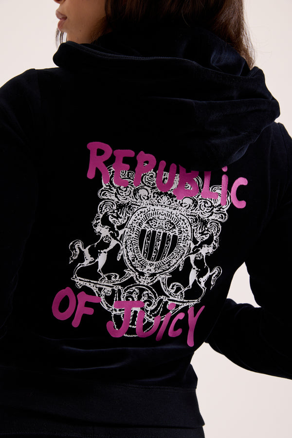 Displays a model wearing the Black Juicy Couture & Roxy Republic of heritage hoodie featuring the republic of juicy branding 