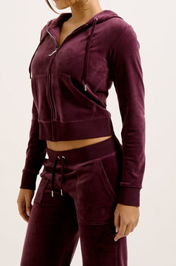 Displays a model wearing the wine tasting classic 'juicy' branded velour Robertson hoodie 