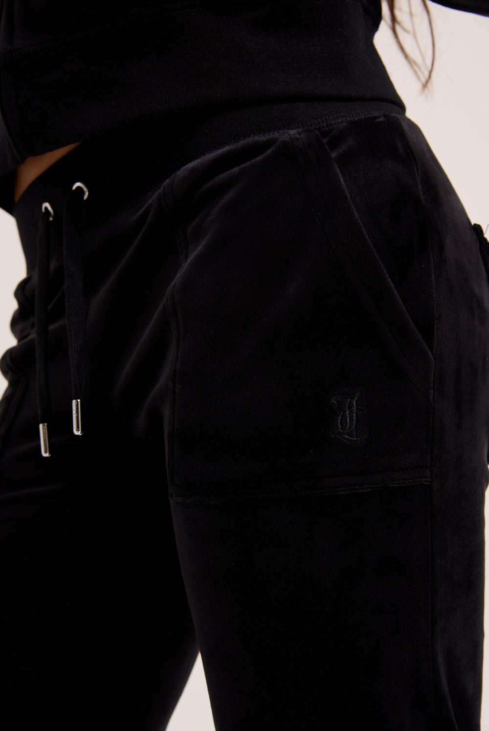 Black pants with drawstring waistband on a plain background