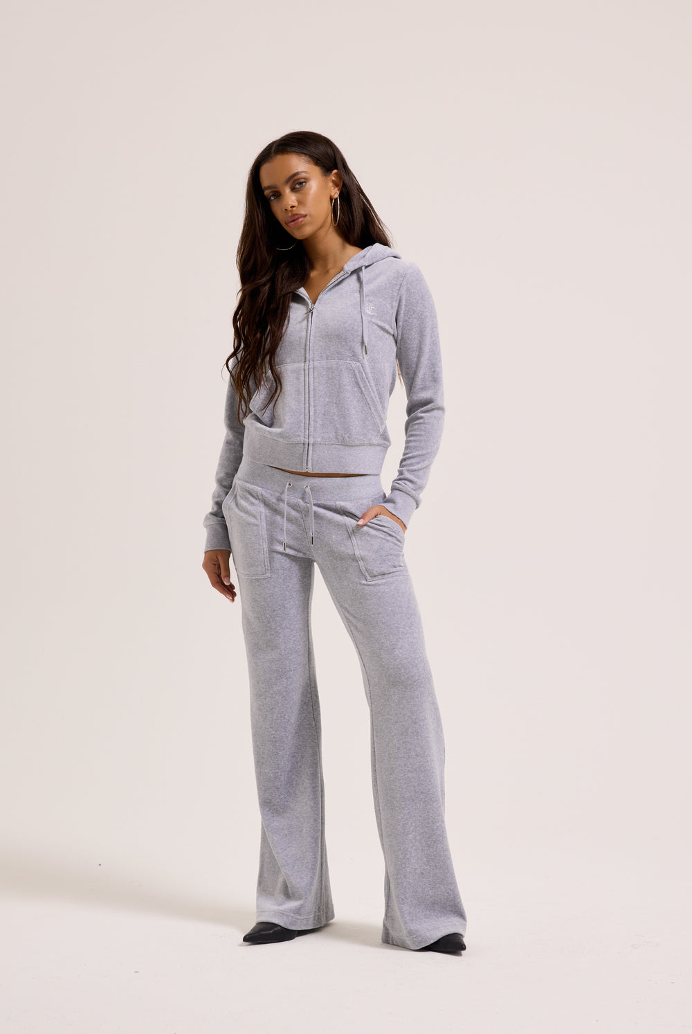 Displays a model wearing the Silver Marl Low Rise 'Juicy' branded cotton velour track pants