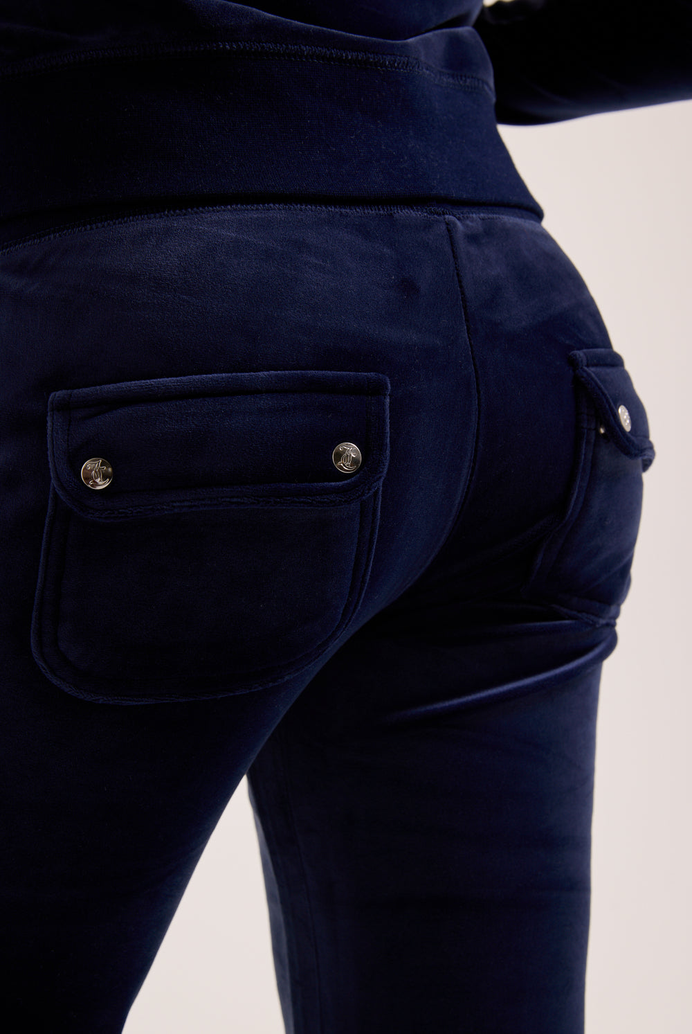 Navy blue pants with button details on a light background