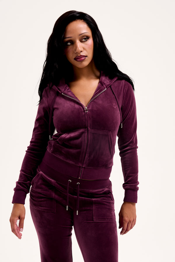 Displays a model wearing the Wine-tasting classic 'juicy' branded velour del ray pocketed 