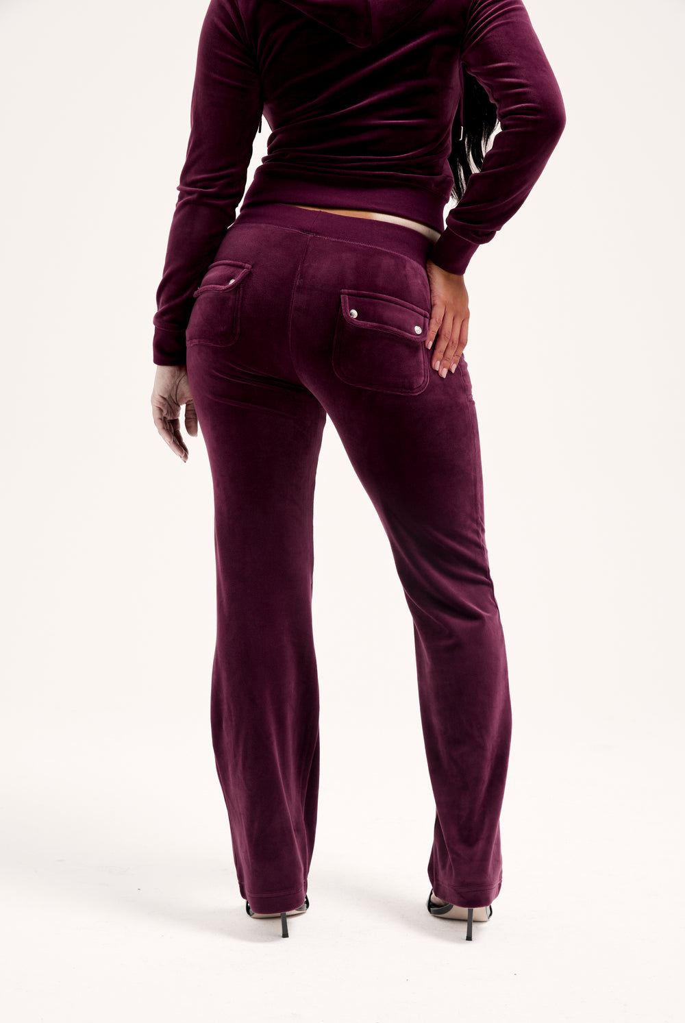 Displays a model wearing the Wine-tasting classic 'juicy' branded velour del ray pocketed 