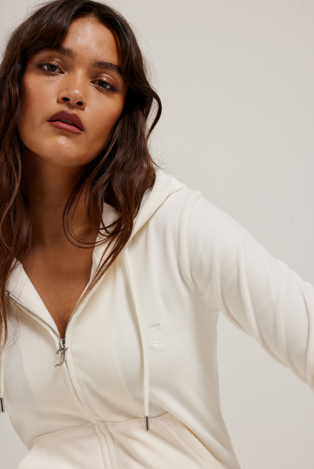 Displays a model wearing the cream classic 'Juicy' branded velour Robertson hoodie 