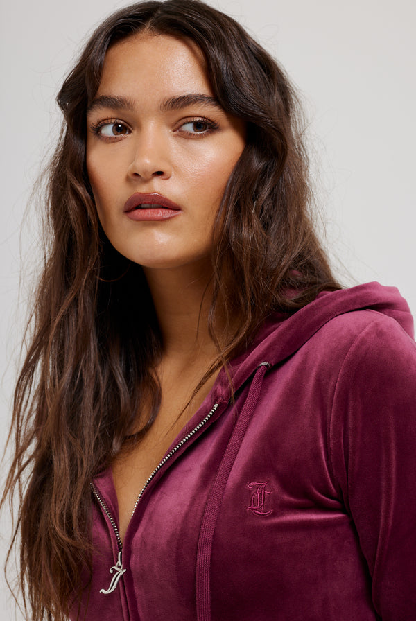 Displays a model wearing the Tawny Port 'Juicy' branded classic velour Robertson hoodie