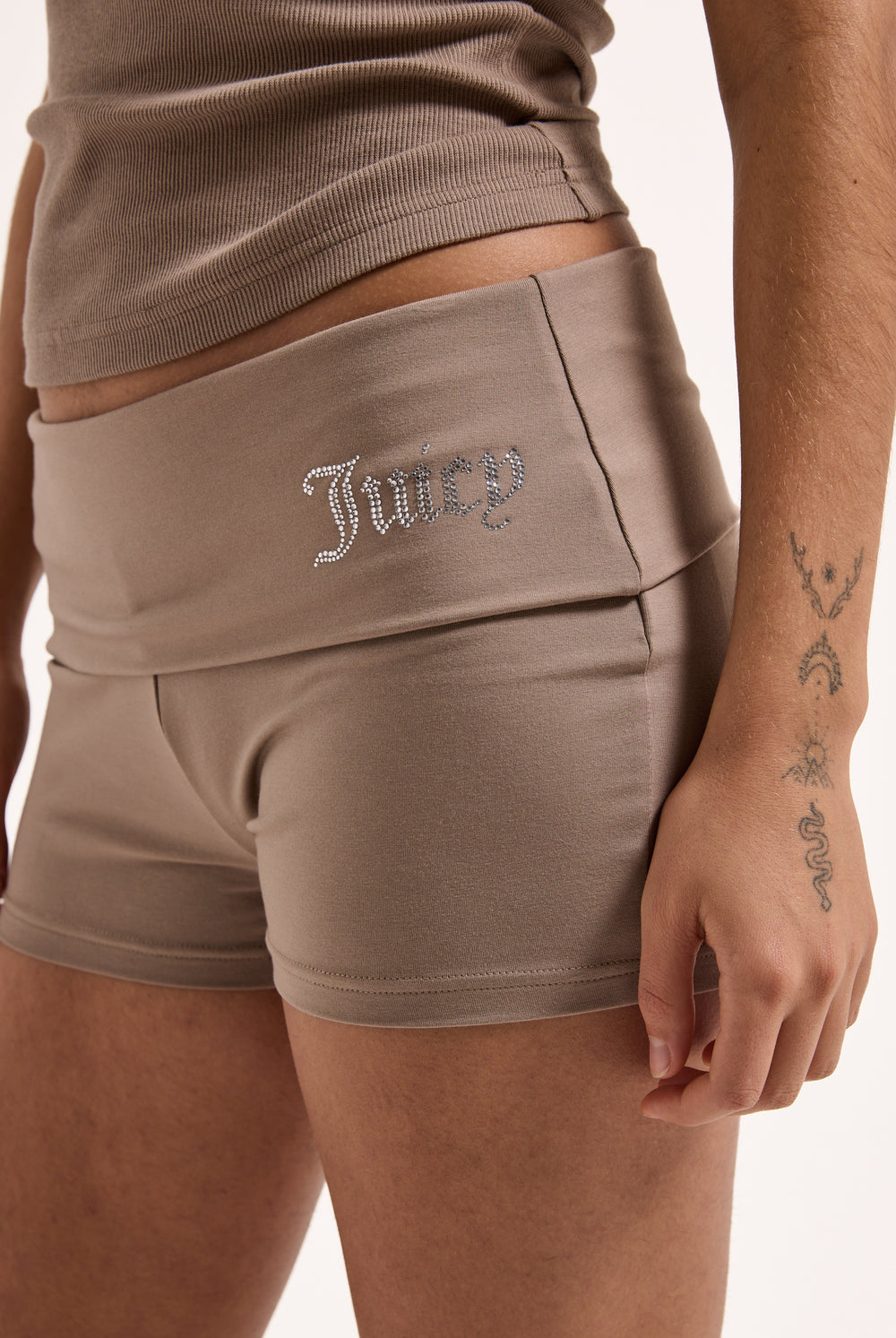 Displays a model wearing the fungi luxury jersey 'juicy' branded roll down diamanté shorts 