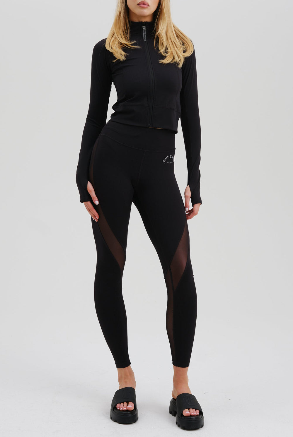 Displays a model wearing the Black 'Juicy' branded black rib peached interlock active legging 