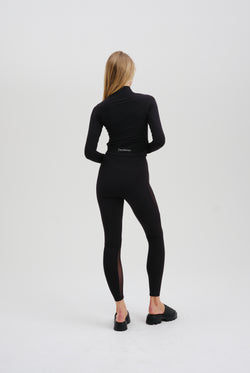 Displays a model wearing the Black 'Juicy' branded black rib peached interlock active legging 