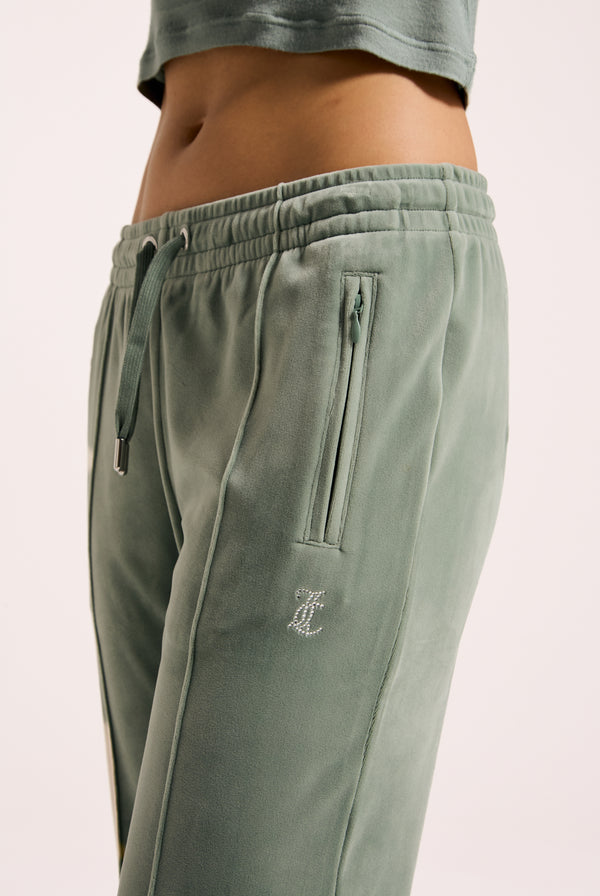 Displays a model wearing the chinois green 'Juicy' velour diamanté tracksuit bottom 