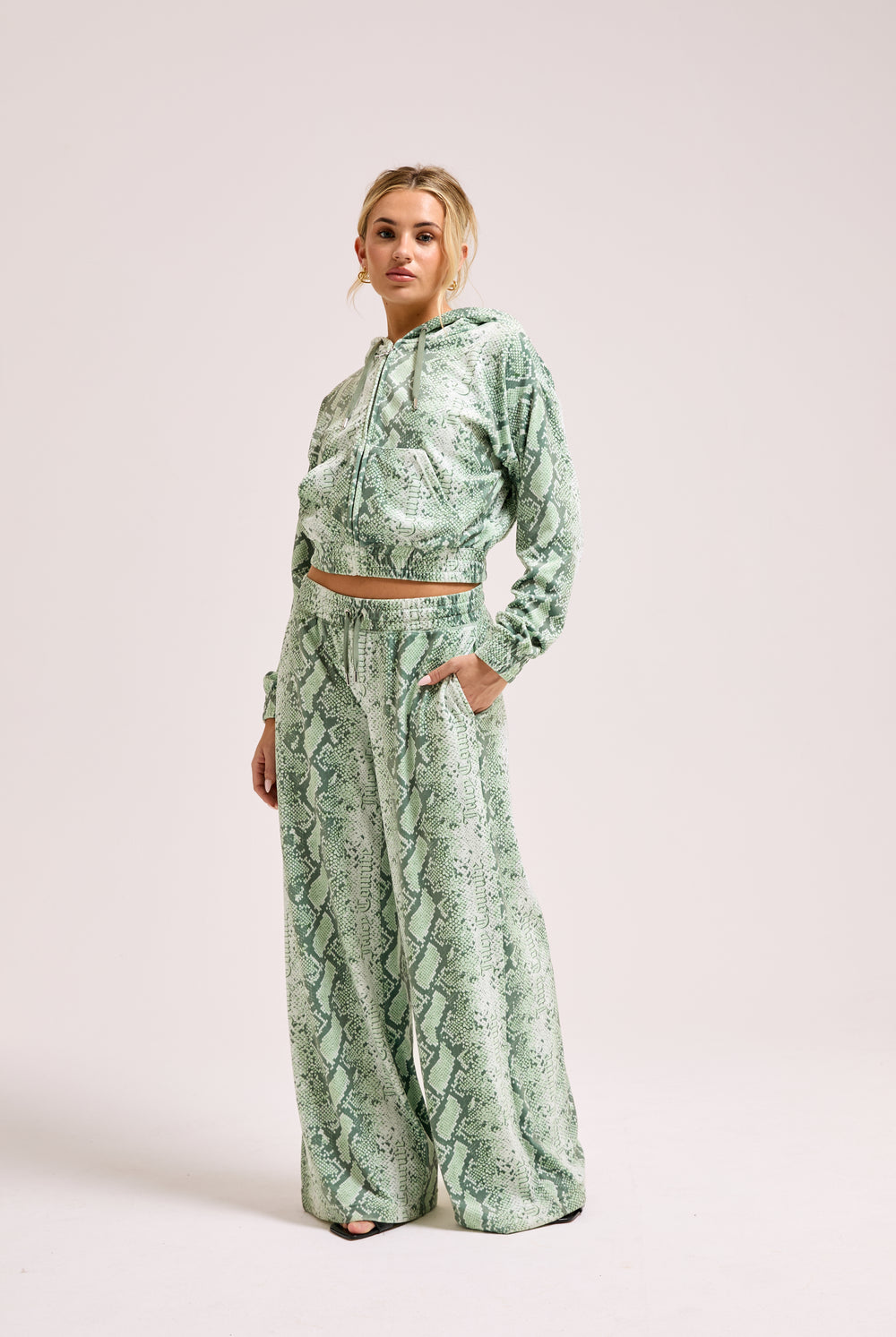 Displays a model wearing the Green snake print 'Juicy' branded diamanté oversized cropped hoodie