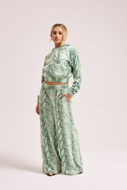Displays a model wearing the Green snake print 'Juicy' branded diamanté oversized cropped hoodie