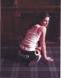 Displays a model wearing the Black Appliqué 'Juicy' branded  Terry booty shorts featuring the juicy branding 
